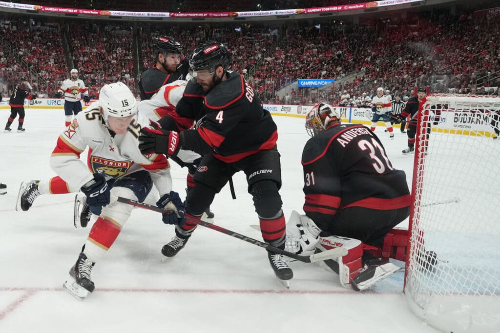 May 22, 2025; Raleigh, North Carolina, USA; Carolina Hurricanes defenseman Shayne Gostibehere (4) defends against Florida Panthers forward Anton Lundell (15) during the first period in game two of the Eastern Conference Final of the 2025 Stanley Cup Playoffs at Lenovo Center. Mandatory Credit: James Guillory-Imagn Images