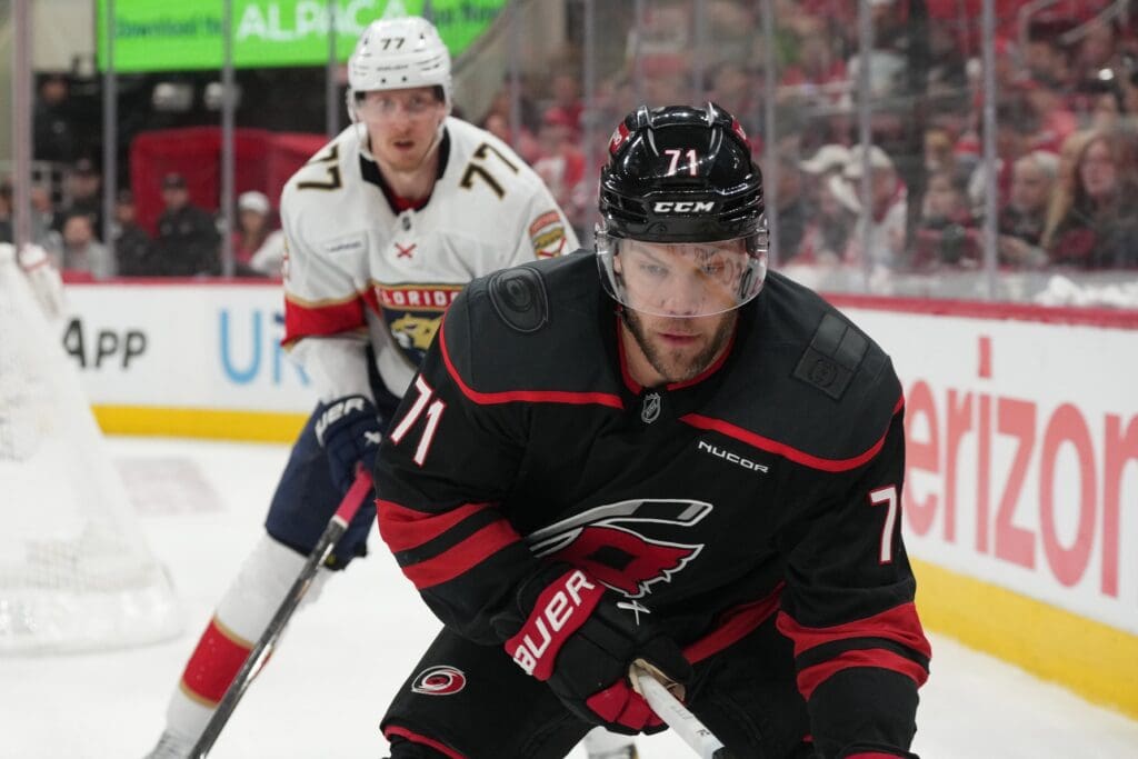 May 22, 2025; Raleigh, North Carolina, USA; Carolina Hurricanes forward Taylor Hall (71) goes into the corner against Florida Panthers defenseman Niko Mikkola (77) during the third period in game two of the Eastern Conference Final of the 2025 Stanley Cup Playoffs at Lenovo Center. Mandatory Credit: James Guillory-Imagn Images