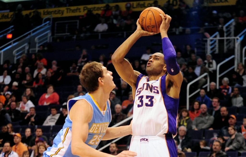 Dec. 22, 2011; Phoenix, AZ, USA; Phoenix Suns small forward Grant Hill (33) puts up a shot against the Denver Nuggets center Timofey Mozgov (25) during the second half of a preseason game at the US Airways Center. The Nuggets defeated the Suns 110-85. Mandatory Credit: Jennifer Stewart-USA TODAY Sports.