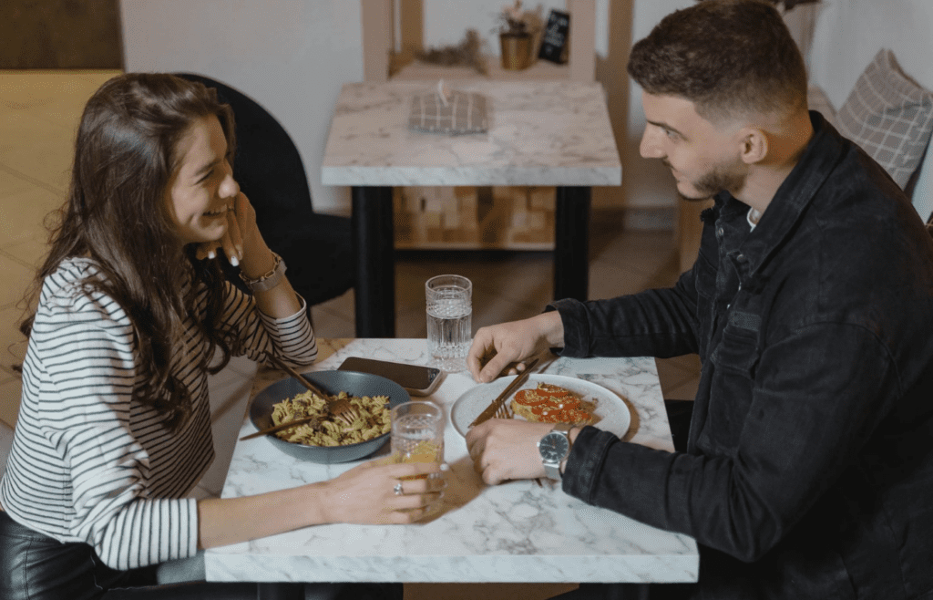 A couple smiling at a dinner table with others