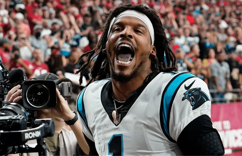 Carolina Panthers quarterback Cam Newton yells \"I'm back!\" after scoring a rushing touchdown against the Arizona Cardinals in a game in 2021