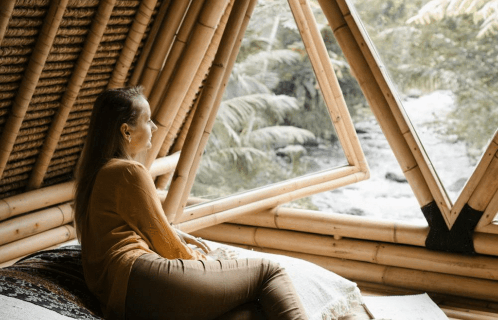 A person taking a deep breath while looking out a window
