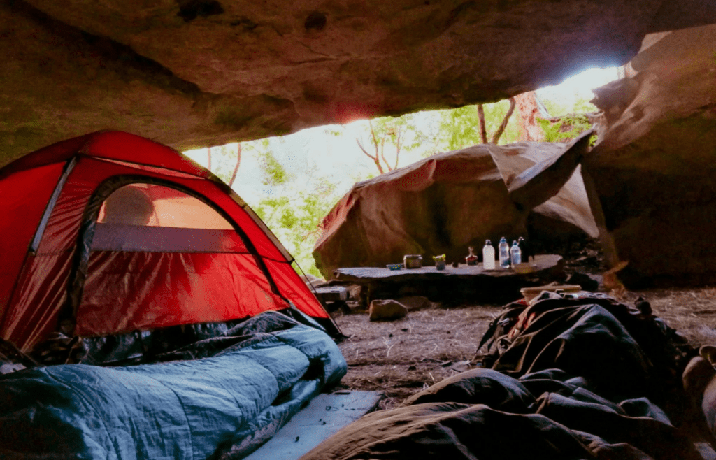 A sleeping bag unrolled on a camping mat