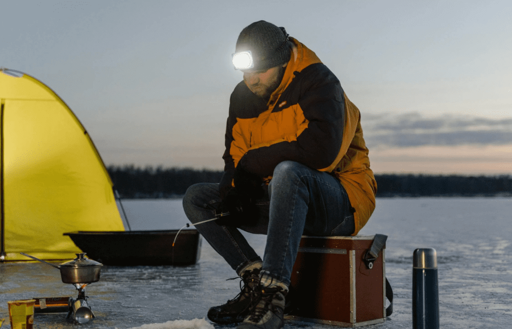A camper wearing a headlamp at dusk