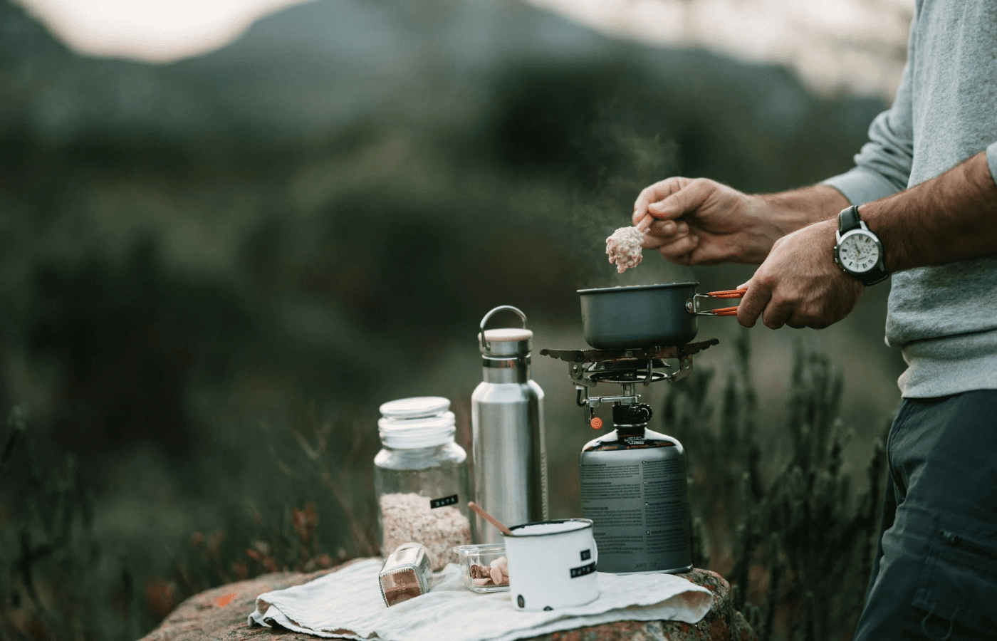 A camping stove with simple food cooking on it