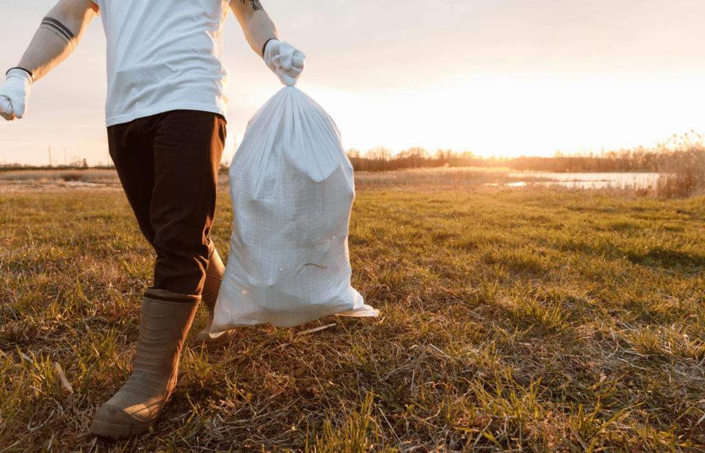 A camper tying up a trash bag at their site