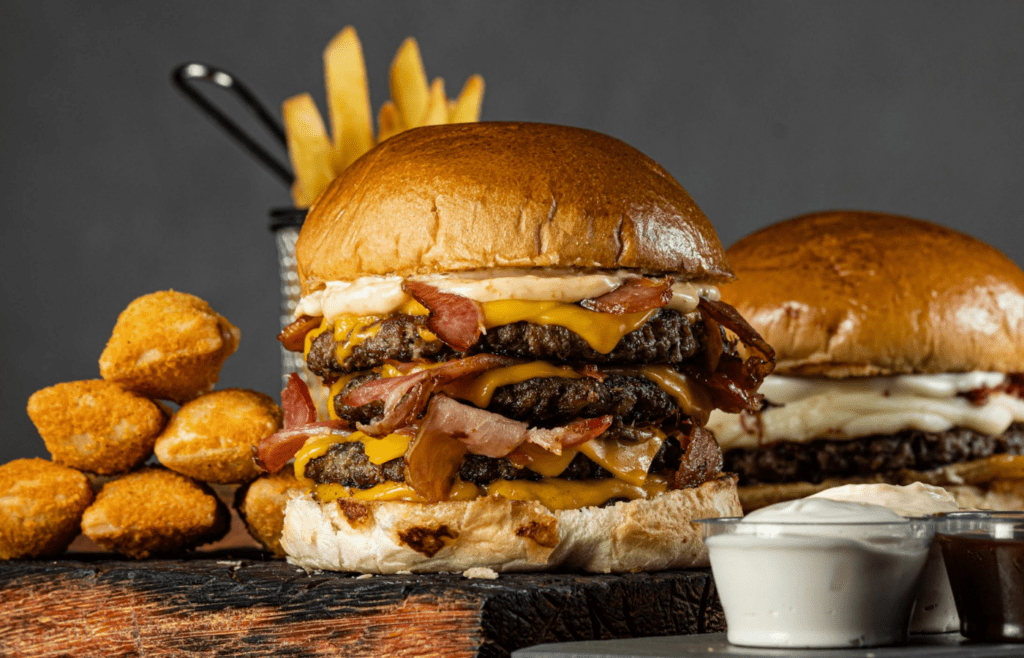 A platter of freshly grilled burgers with cheese and toppings