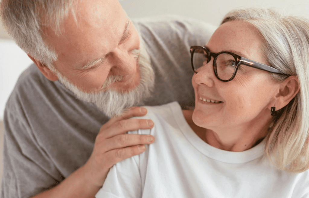 A couple smiling at each other, graying hair visible
