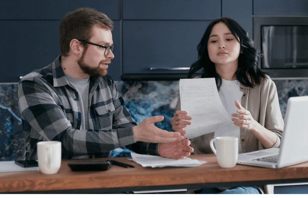 A couple reviewing bills or finances at the kitchen table