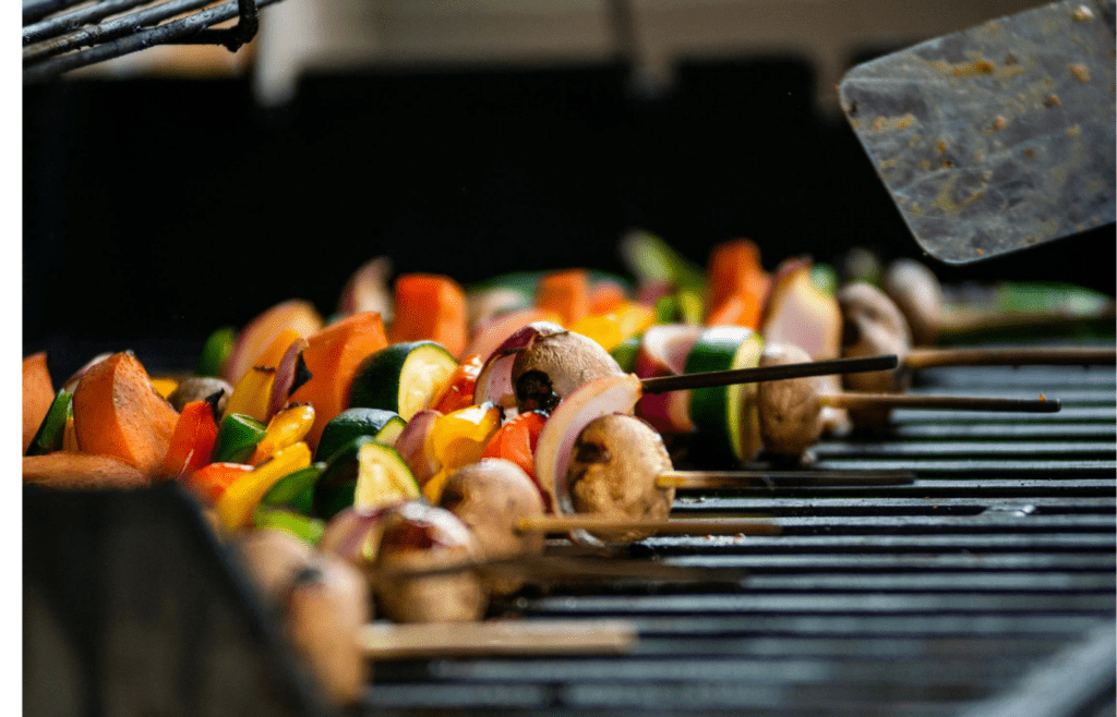 Colorful veggie skewers grilling over flames
