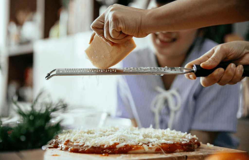 Personal-sized pizzas cooking on a campfire grate