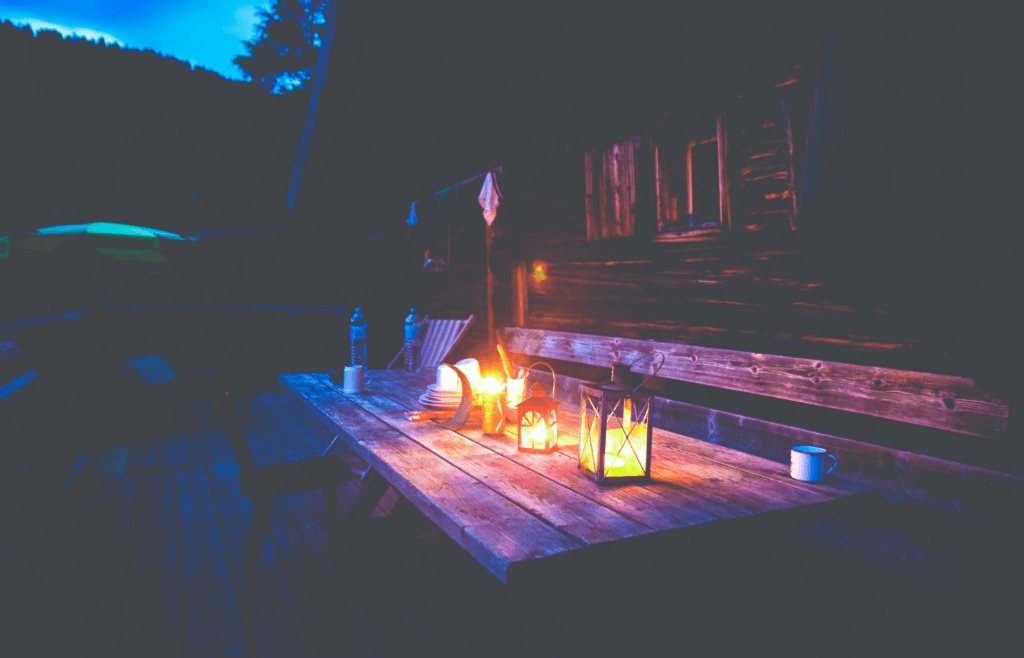 A group of metal and glass lanterns on a patio table