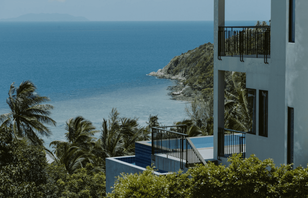 A hotel room balcony overlooking a scenic beach or cityscape