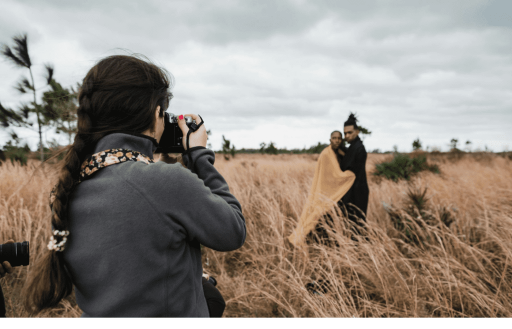 A photographer snapping photos of a couple at a scenic spot