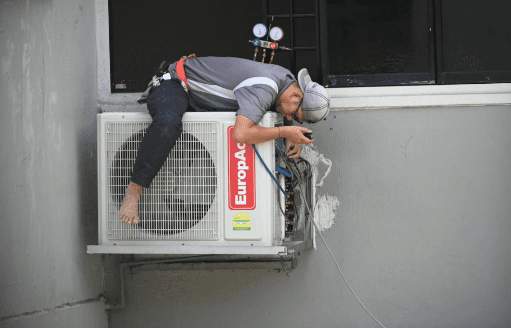 A technician inspecting an air conditioner unit