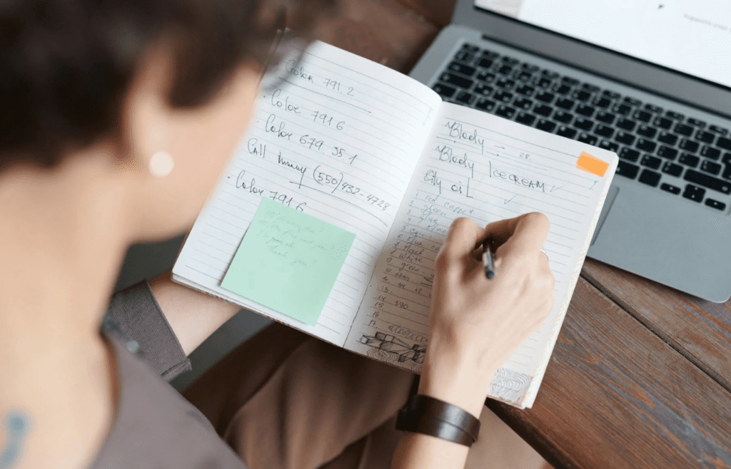 A person making a list in a notebook