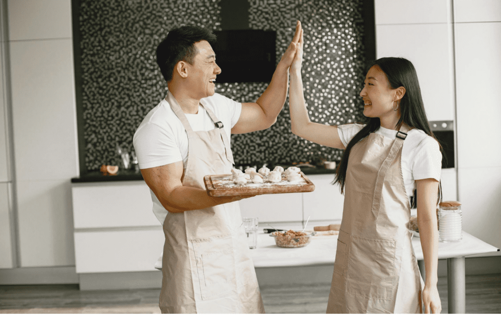 A couple laughing while cooking together