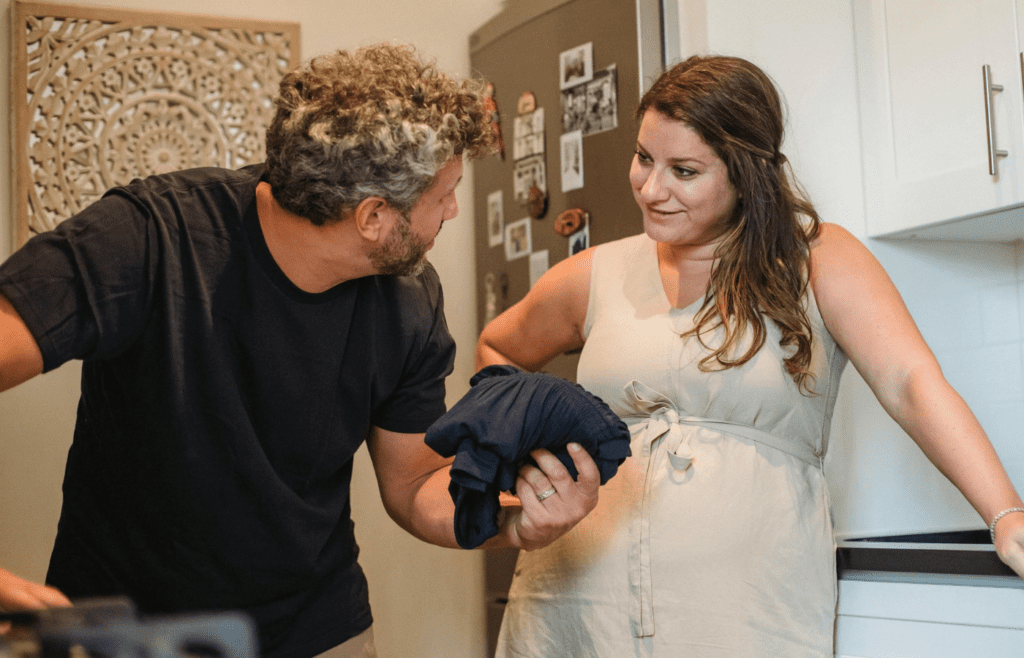 A couple folding laundry together with smiles