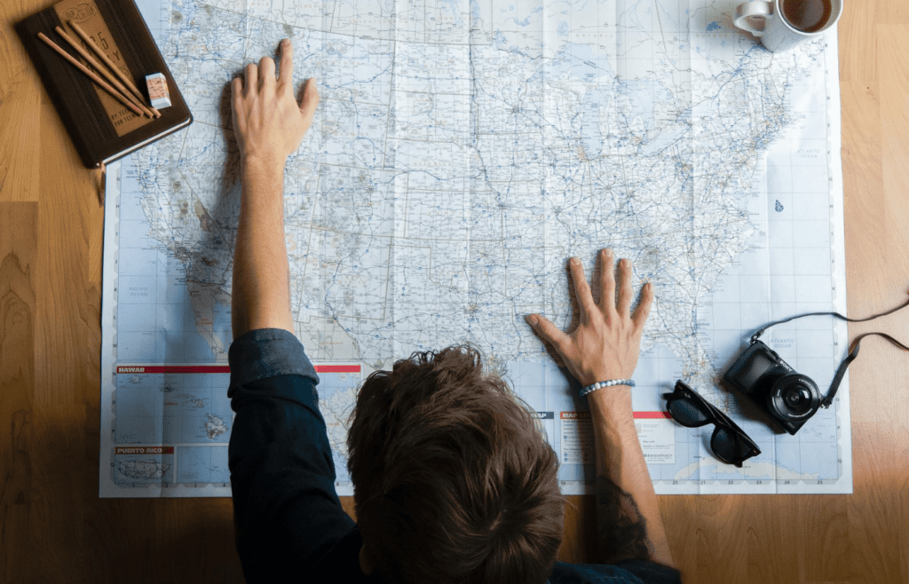 A traveler adjusting plans with a map and coffee