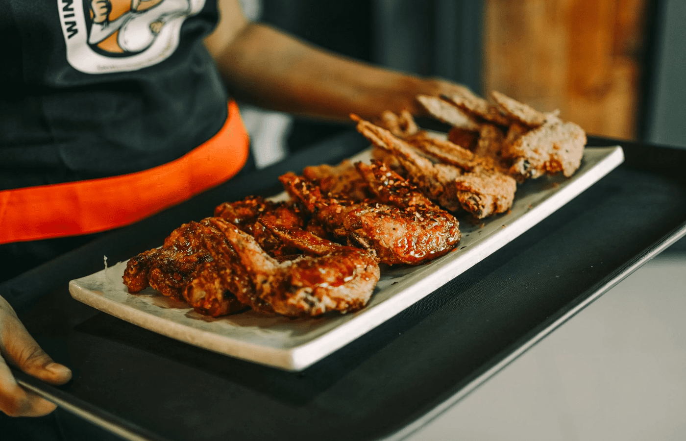 A baking tray of partially cooked chicken pieces