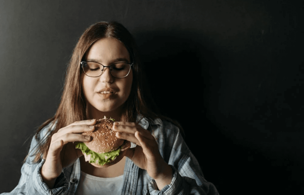 A person holding fast food with a stressed look
