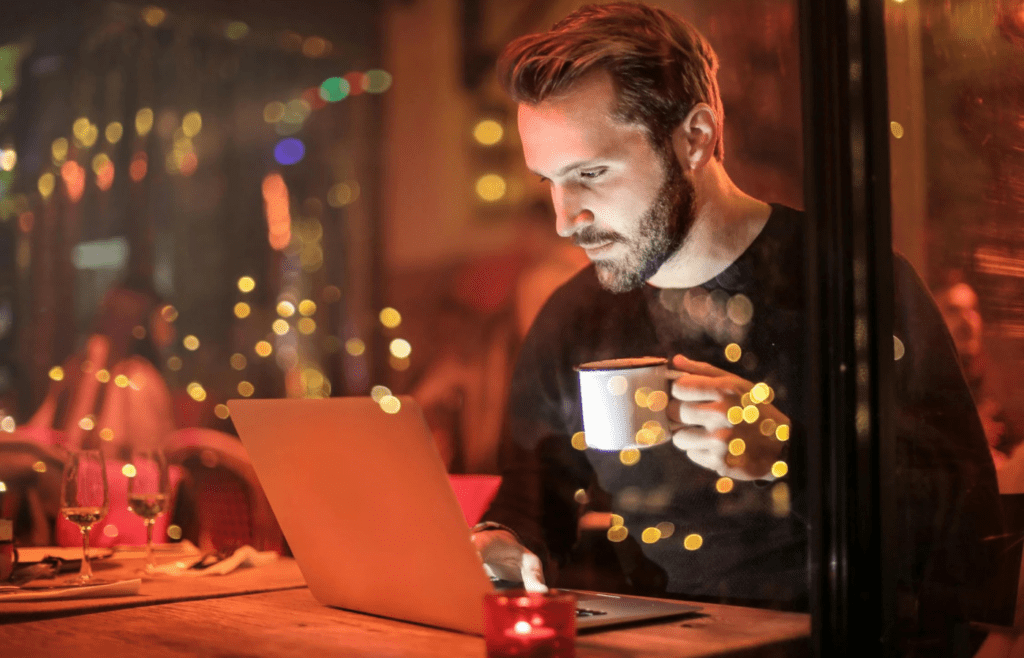 A person holding a large cup of coffee with shaky hands