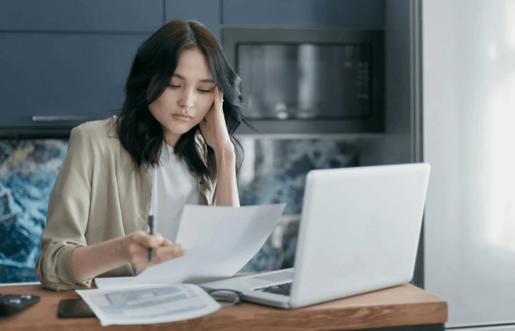 A person staring blankly at a cluttered workspace