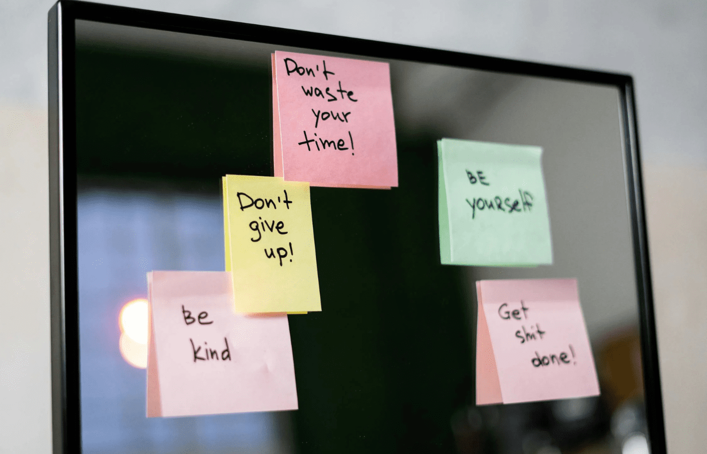 A sticky note with a heart on a fridge or mirror