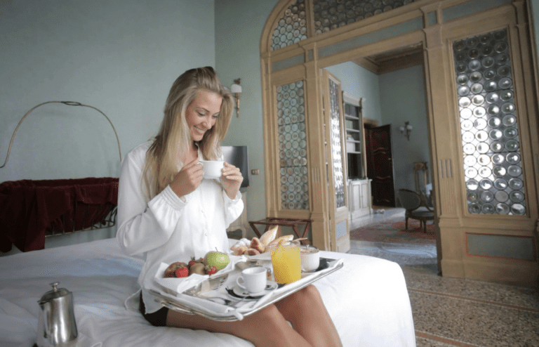 A breakfast tray on a hotel bed with fresh coffee
