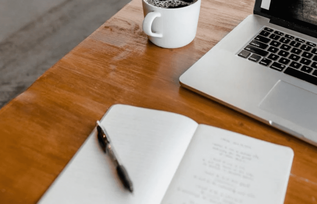 A notebook and pen on a nightstand