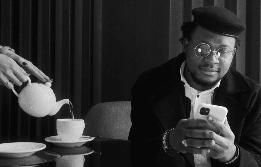 A phone face down next to a cup of tea