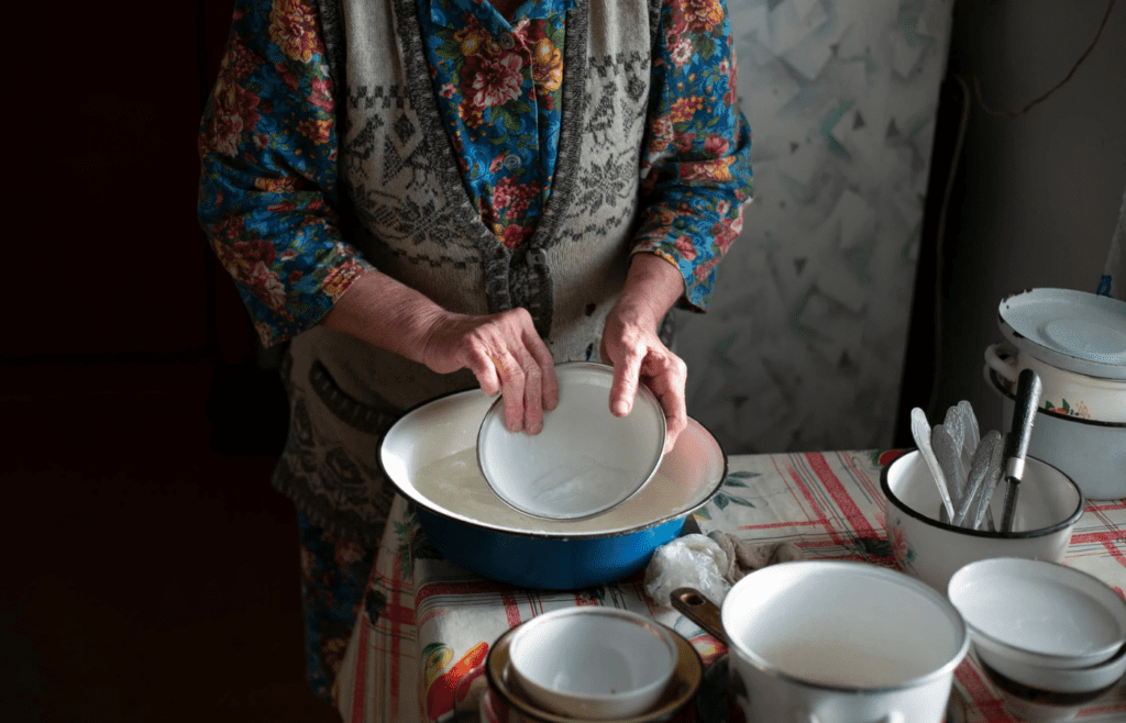 A person washing dishes calmly