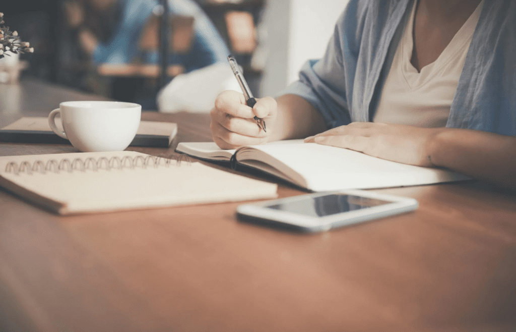 A person writing rapidly in a notebook