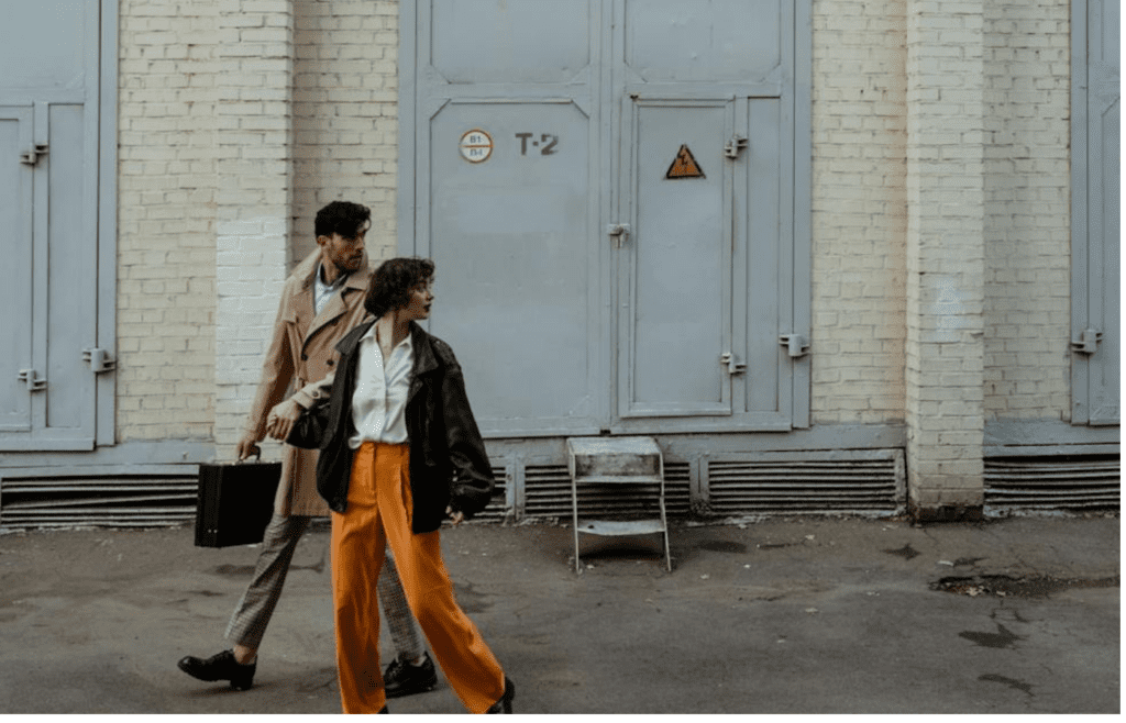 A couple looking in different directions while walking