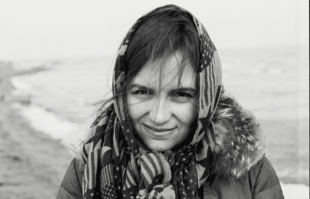 A traveler wrapping up in a scarf at an outdoor cafe