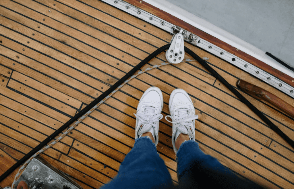 A person rolling sealant onto a wooden deck