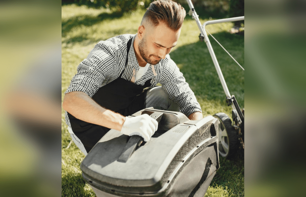 A person checking a lawn mower in a garage