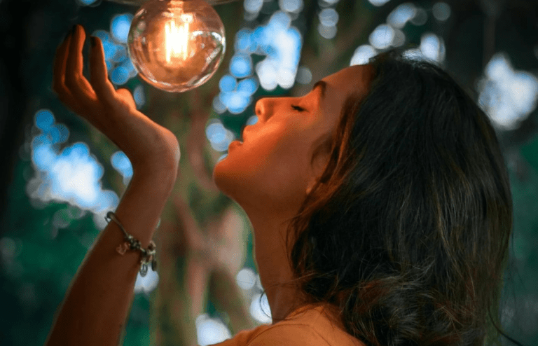 A person replacing a bulb in a backyard light fixture