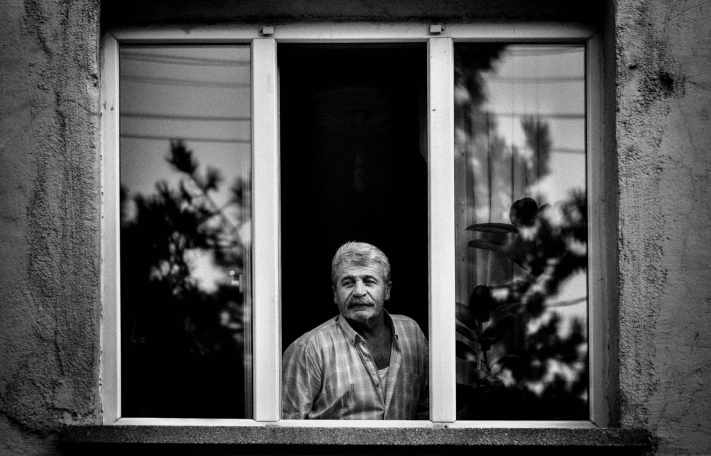 A person caulking around a window frame