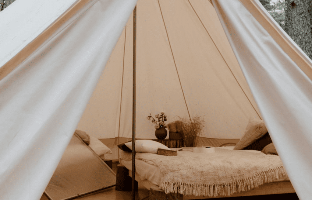 A tent interior with real pillows and a cozy quilt