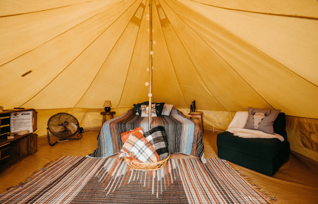 A colorful outdoor rug spread across a tent floor