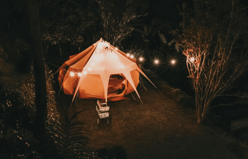 Fairy lights strung up inside a tent or across camp trees