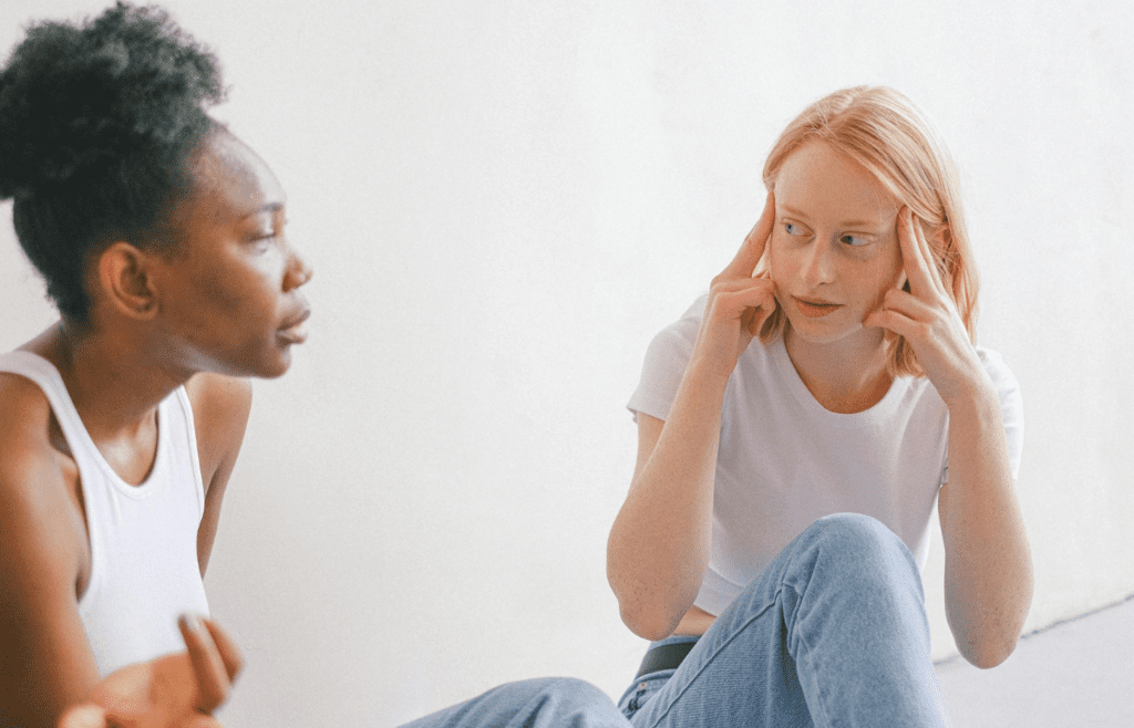 A dismissive person gesturing as the other looks hurt