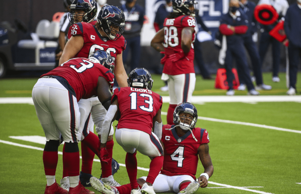 Dec 6, 2020; Houston, Texas, USA; Houston Texans quarterback Deshaun Watson (4) is helped up after a Texans turnover during the fourth quarter against the Indianapolis Colts at NRG Stadium. Mandatory Credit: Troy Taormina-Imagn Images