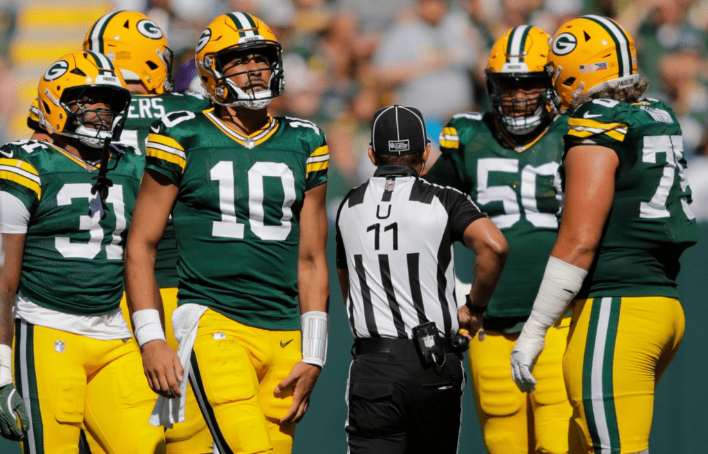 Green Bay Packers quarterback Jordan Love (10) grabs his leg after running the ball against the Minnesota Vikings during their football game Sunday, September 29, 2024, at Lambeau Field in Green Bay, Wisconsin.