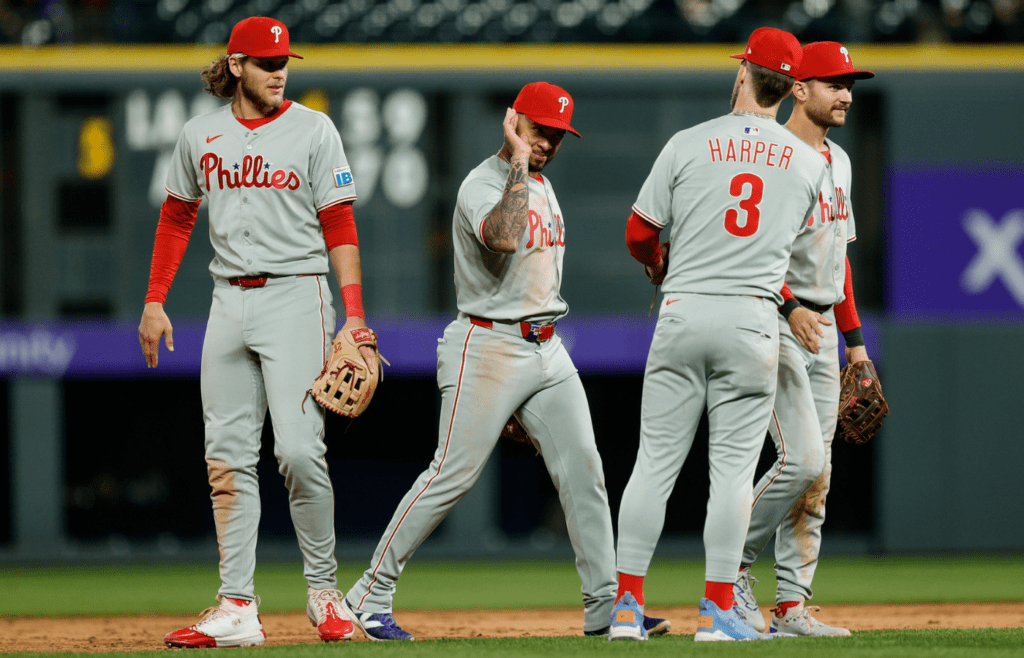 May 19, 2025; Denver, Colorado, USA; Philadelphia Phillies second baseman Edmundo Sosa (33) and third baseman Alec Bohm (28) and first baseman Bryce Harper (3) and shortstop Trea Turner (7) celebrate after the game against the Colorado Rockies at Coors Field. Mandatory Credit: Isaiah J. Downing-Imagn Images