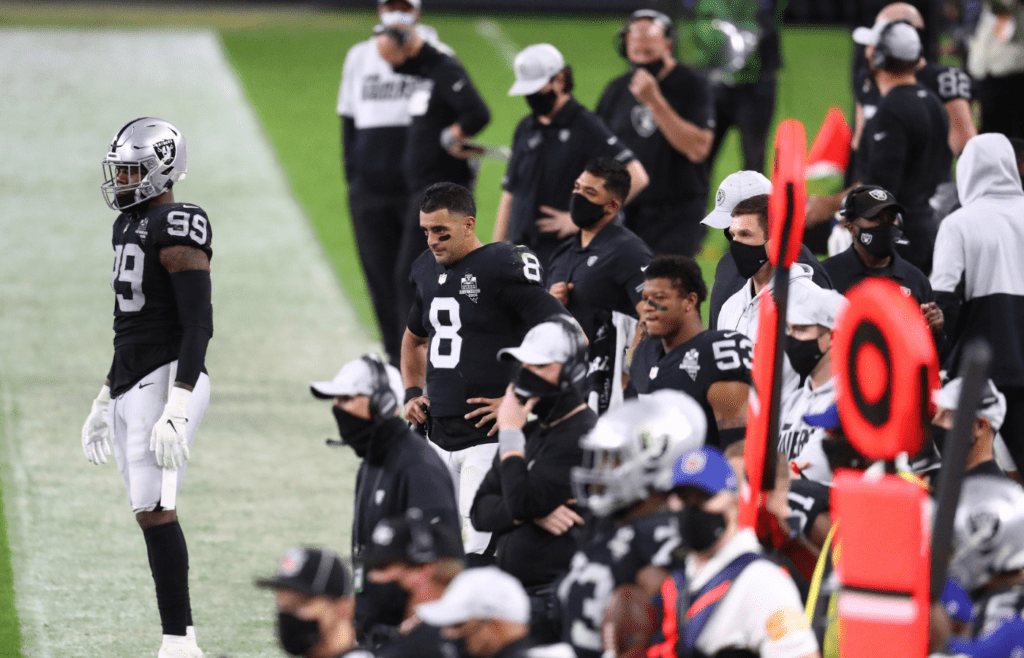 Dec 17, 2020; Paradise, Nevada, USA; Las Vegas Raiders defensive end Arden Key (99) quarterback Marcus Mariota (8) and the sideline watch game action against the Los Angeles Chargers during the second half at Allegiant Stadium. Mandatory Credit: Mark J. Rebilas-Imagn Images