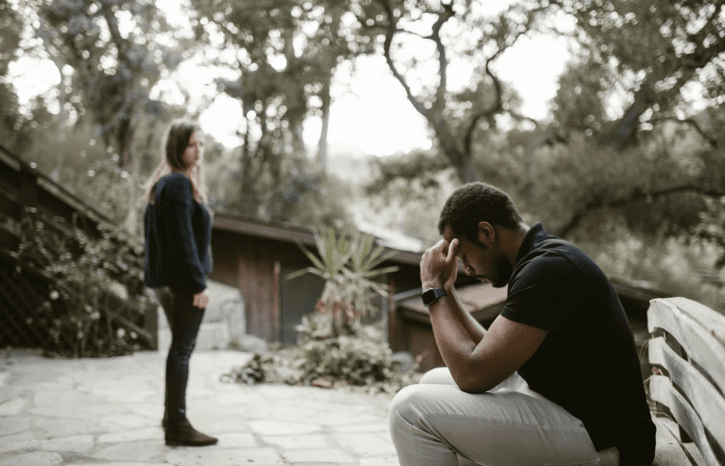 A person looking sad while someone else looks frustrated