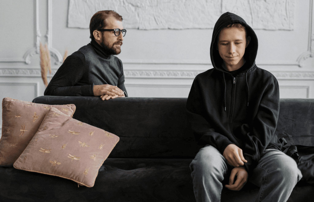 Two people sitting in silence on opposite ends of a couch