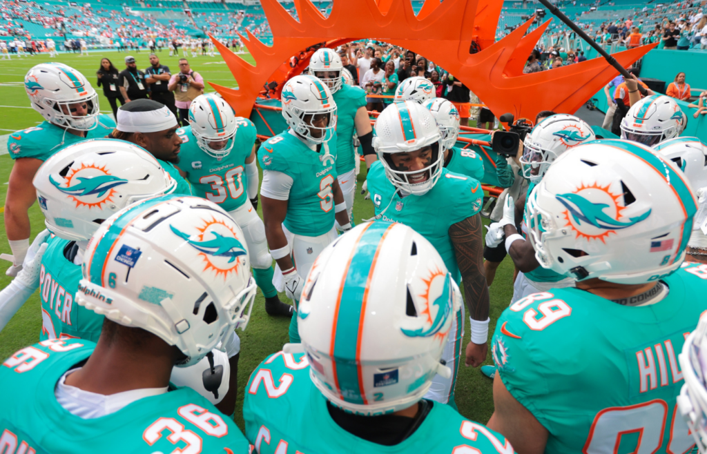 Dec 22, 2024; Miami Gardens, Florida, USA; Miami Dolphins quarterback Tua Tagovailoa (1) talks to his teammates before the game against the San Francisco 49ers at Hard Rock Stadium. Mandatory Credit: Sam Navarro-Imagn Images